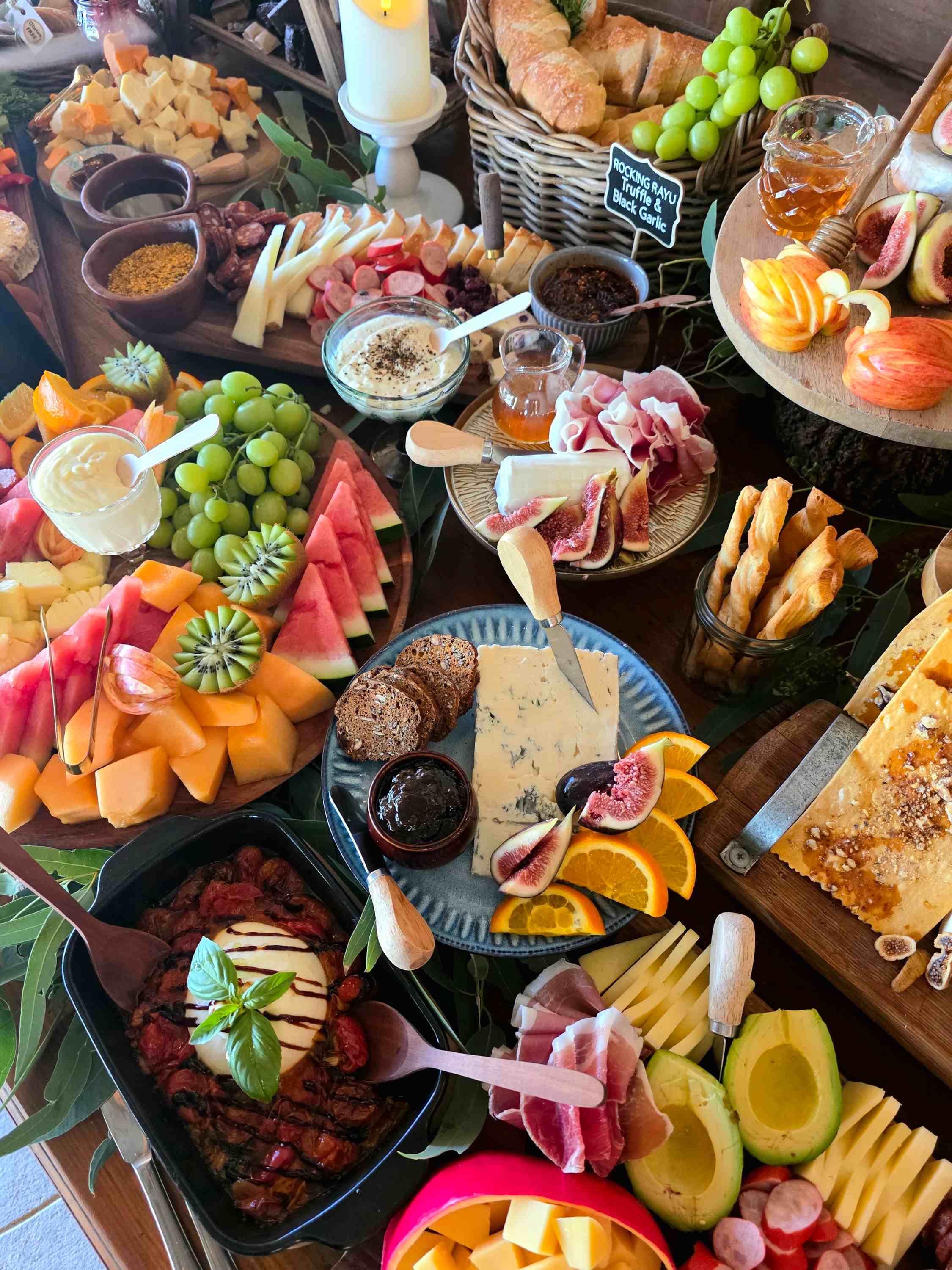 Grazing table spread with cheese, fruit and charcuterie